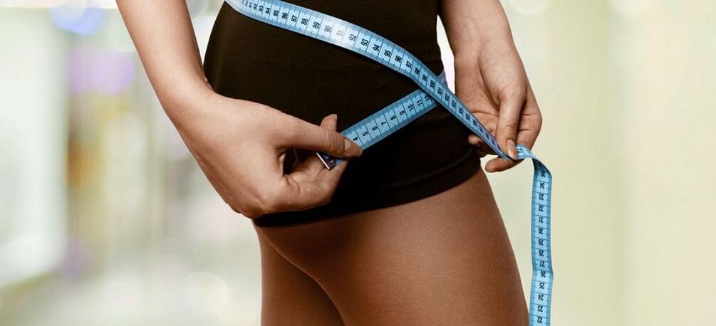 एक महिला प्रभावी वजन घटाने के परिणाम रिकॉर्ड करती है